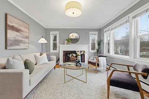 a living room with furniture a fireplace and a large window