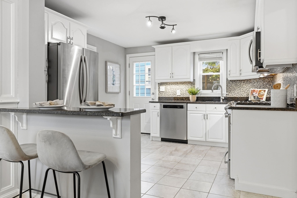 5 Baker Street Boston, MA 02132 - Photo 17 of 40 a kitchen with appliances cabinets and chair