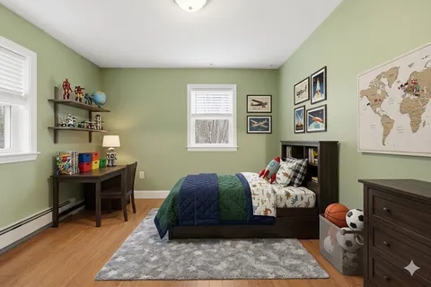 a bedroom with a bed and wooden floor