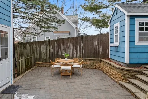 a backyard of a house with table and chairs