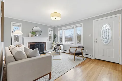 a living room with furniture a fireplace and a large window