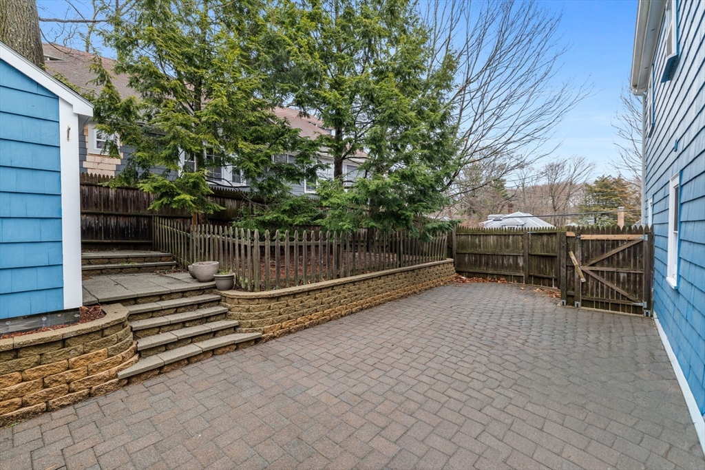5 Baker Street Boston, MA 02132 - Photo 32 of 40 a view of backyard with wooden fence and large trees