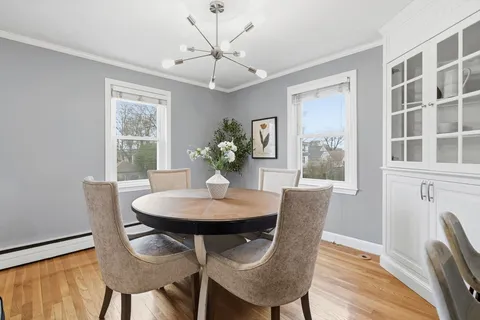 a dining room with furniture a chandelier and wooden floor