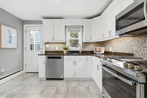 a kitchen with a stove and white cabinets
