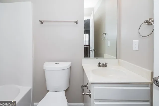 a bathroom with a toilet sink and a mirror