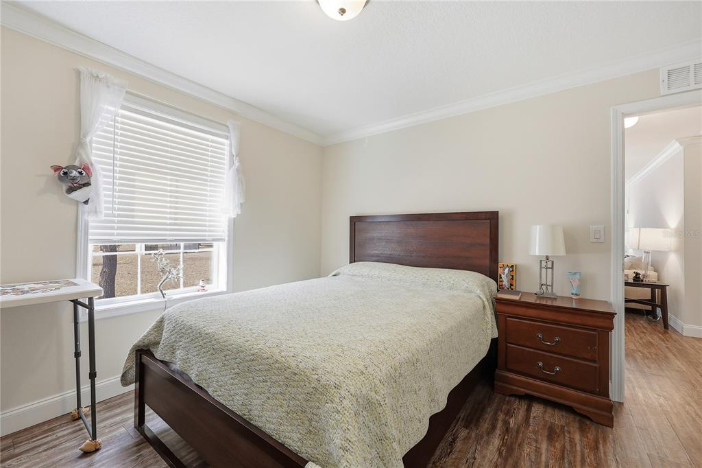 5530 Northeast 103rd Terrace Bronson, FL 32621 - Photo 12 of 29 a bedroom with a bed and wooden floor