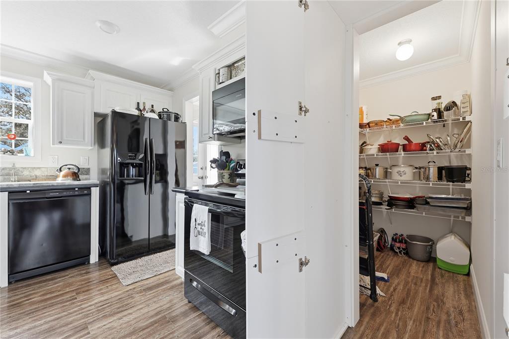 5530 Northeast 103rd Terrace Bronson, FL 32621 - Photo 16 of 29 a kitchen with a refrigerator and a wooden floor