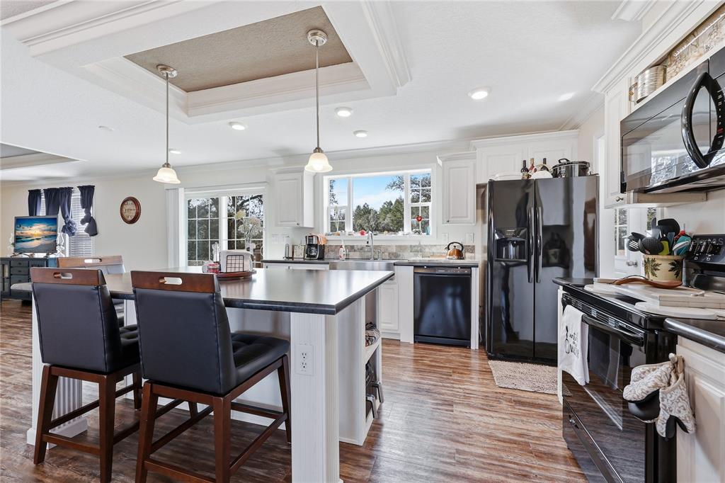 5530 Northeast 103rd Terrace Bronson, FL 32621 - Photo 20 of 29 a kitchen with stainless steel appliances granite countertop dining table chairs refrigerator and sink