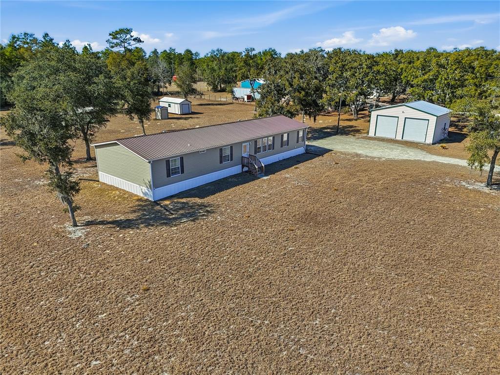 5530 Northeast 103rd Terrace Bronson, FL 32621 - Photo 23 of 29 a view of a white house with a yard and sitting area