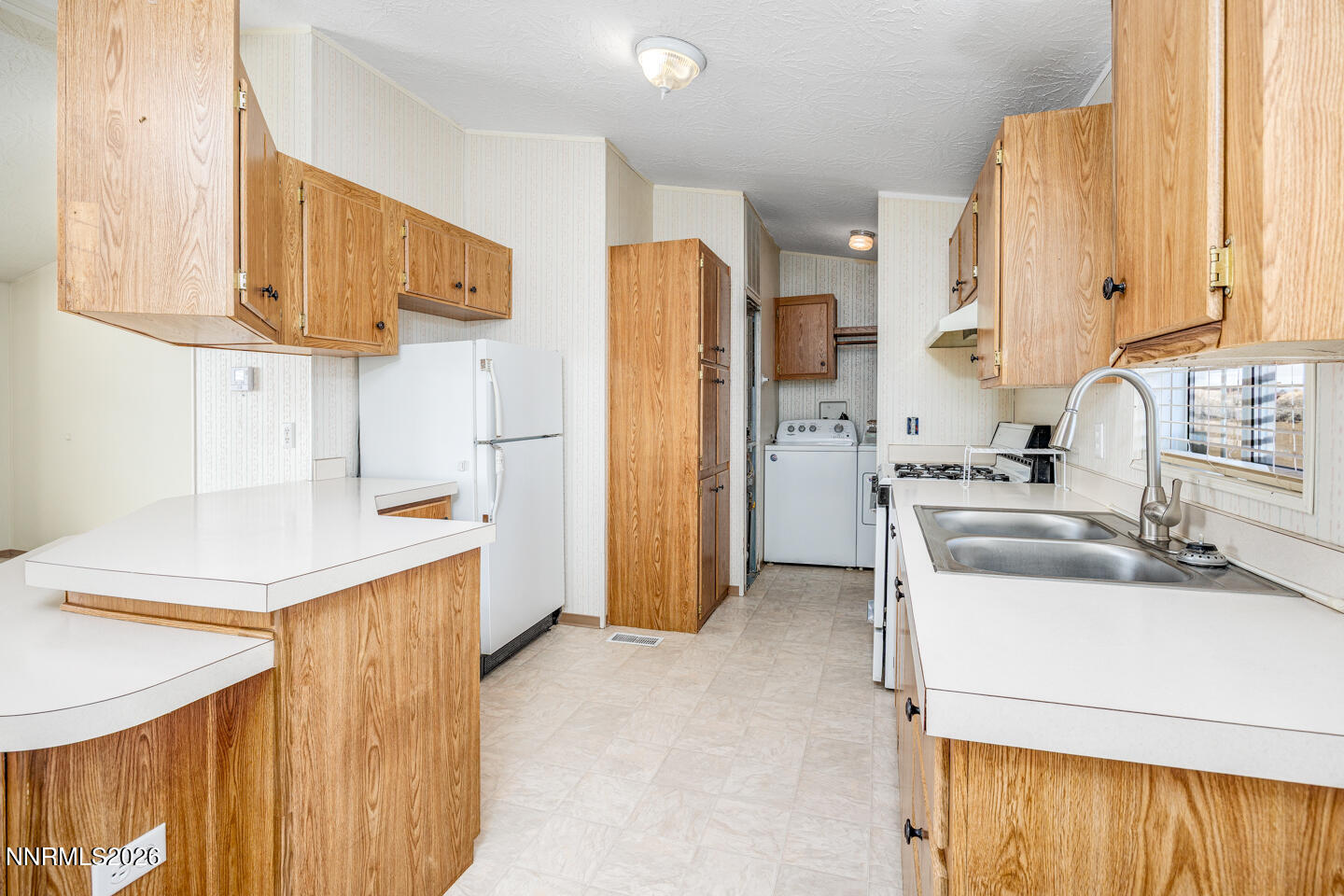6312 Sierra Way Fallon, NV 89406 - Photo 5 of 20 a kitchen with a sink a refrigerator a stove and a window