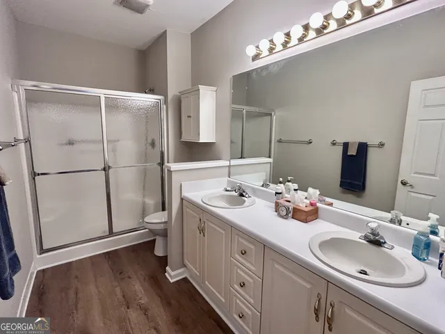 a bathroom with a double vanity sink mirror and toilet