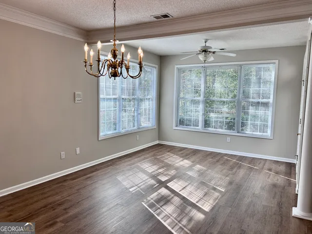 a view of a room with wooden floor chandeliers and kitchen