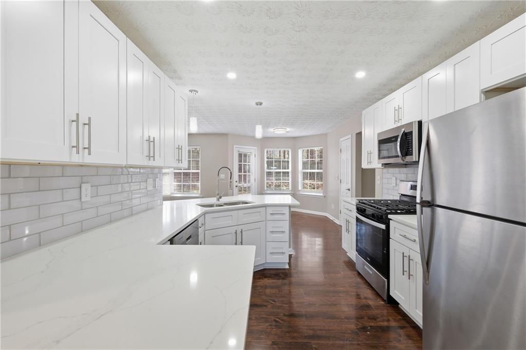 3570 Bogan Mill Road Northeast Buford, GA 30519 - Photo 5 of 31 a large kitchen with cabinets a refrigerator and a stove top oven