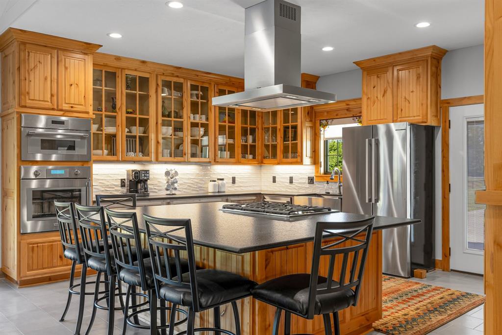 2072 East US 69 Emory, TX 75440 - Photo 11 of 39 a kitchen with stainless steel appliances granite countertop a stove a refrigerator a kitchen island a table and chairs