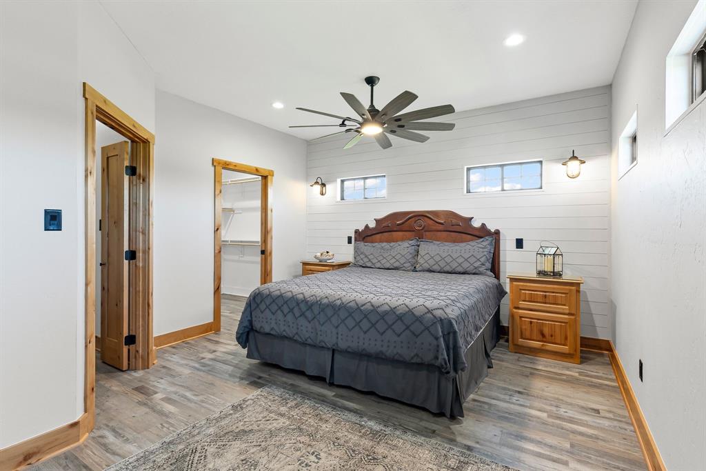 2072 East US 69 Emory, TX 75440 - Photo 20 of 39 a spacious bedroom with a bed and a chandelier