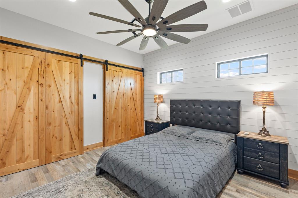 2072 East US 69 Emory, TX 75440 - Photo 23 of 39 a bedroom with a bed and a chandelier