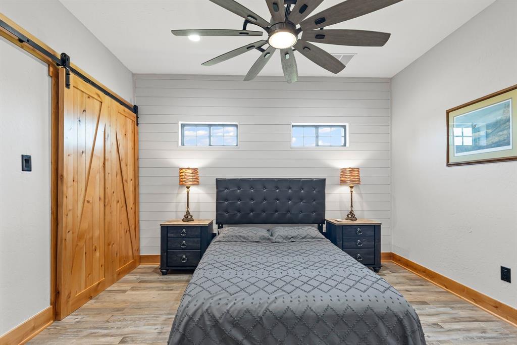 2072 East US 69 Emory, TX 75440 - Photo 24 of 39 a bedroom with a bed and a chandelier