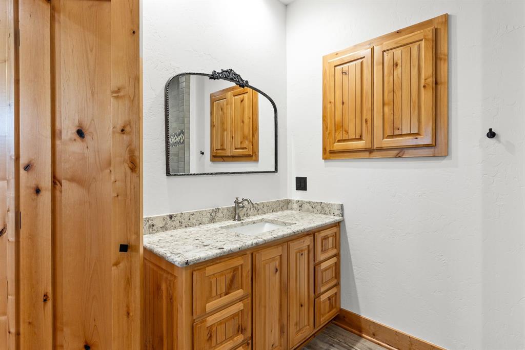 2072 East US 69 Emory, TX 75440 - Photo 30 of 39 a bathroom with a granite countertop sink and a mirror