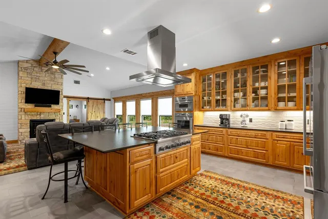 a kitchen with stainless steel appliances granite countertop a sink and a refrigerator