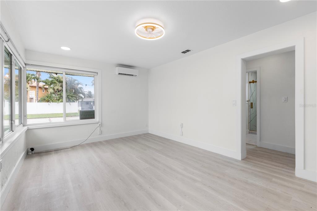14060 Miramar Avenue, Unit 1 #2 #3 #4 Madeira Beach, FL 33708 - Photo 18 of 38 a view of an empty room with a window and wooden floor