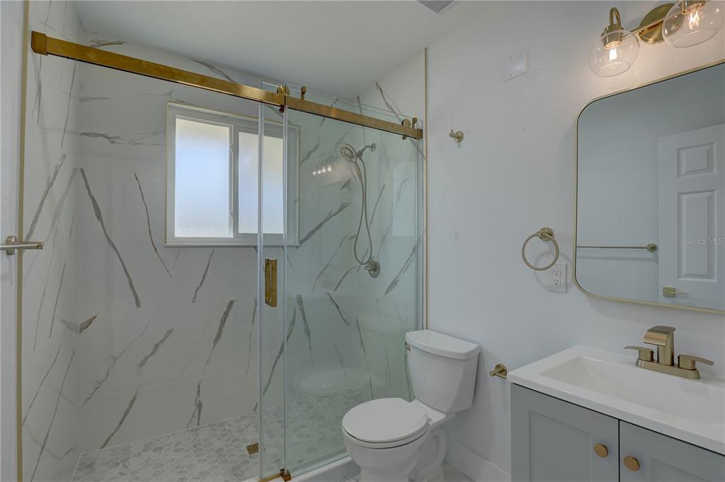 14060 Miramar Avenue, Unit 1 #2 #3 #4 Madeira Beach, FL 33708 - Photo 29 of 38 a bathroom with a shower toilet and sink