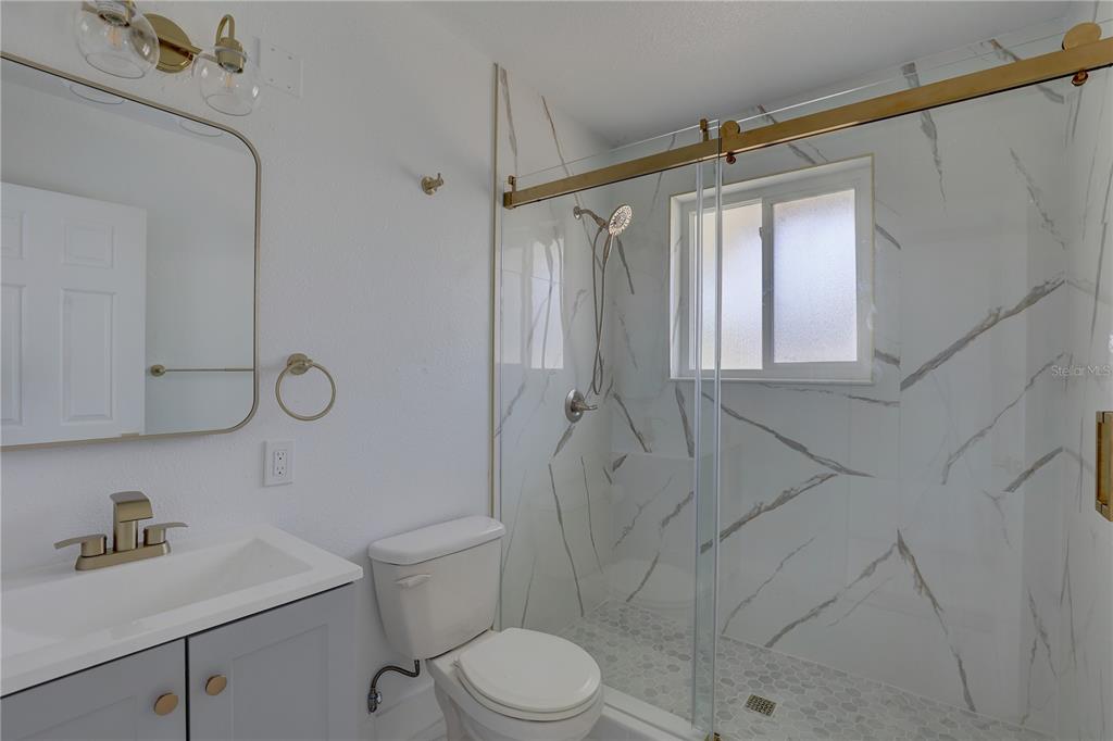 14060 Miramar Avenue, Unit 1 #2 #3 #4 Madeira Beach, FL 33708 - Photo 30 of 38 a bathroom with a sink a toilet and shower