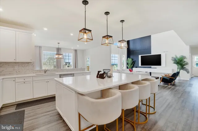 a view of kitchen with sink island and chairs