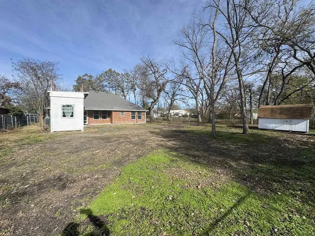 a backyard of a house with large trees and outdoor space