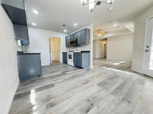 a view of kitchen with refrigerator stove microwave and cabinets