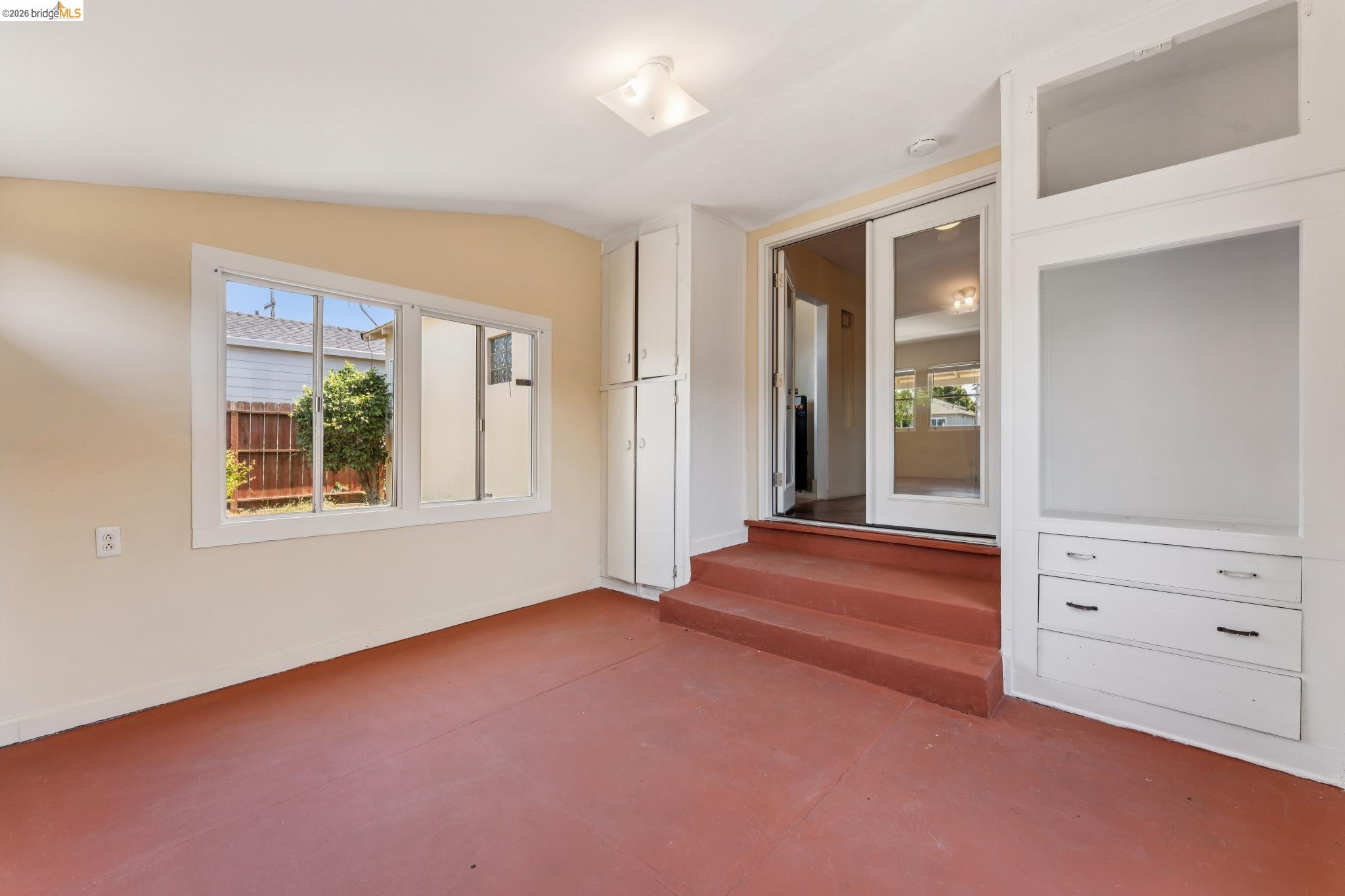 2879 Rheem Avenue Richmond, CA 94804 - Photo 25 of 45 Enclosed sunroom with red-toned flooring, built-in storage cabinetry, and dual-pane windows