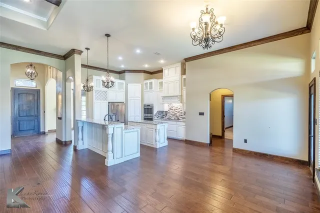 a view of a kitchen with refrigerator and wooden floor