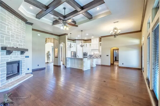 a view of a hall with a fireplace and wooden floor