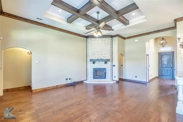 an empty room with wooden floor and a fireplace