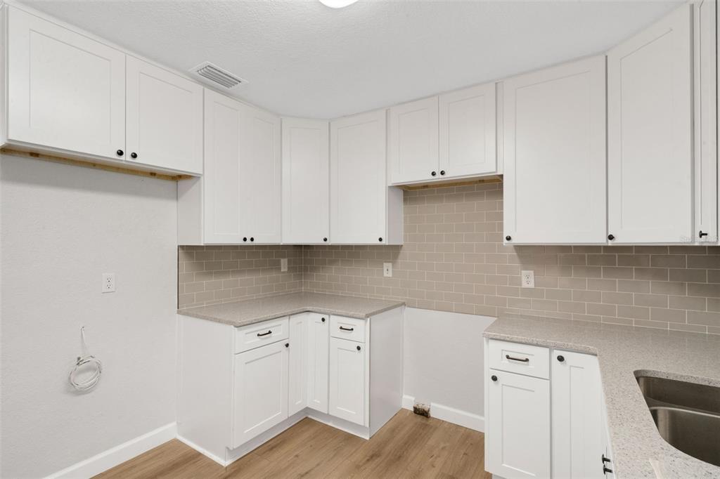 2716 Hardin Combee Road Lakeland, FL 33801 - Photo 13 of 32 a kitchen with granite countertop white cabinets and white appliances