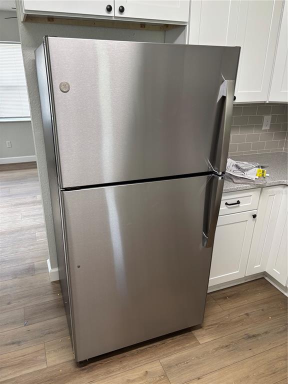 2716 Hardin Combee Road Lakeland, FL 33801 - Photo 5 of 32 a view of a refrigerator in kitchen and an empty room with wooden floor