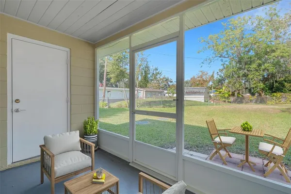 a view of a porch with furniture and garden