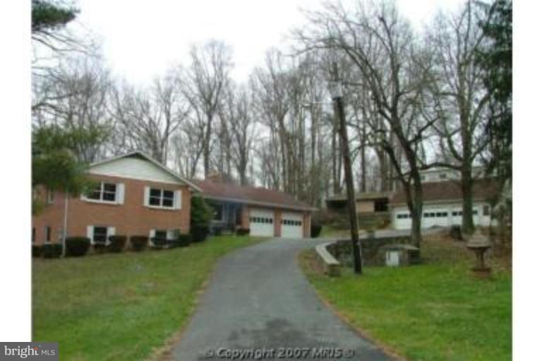8369 Ball Road Frederick, MD 21704 - Photo 1 of 5 a front view of a house with a garden and trees