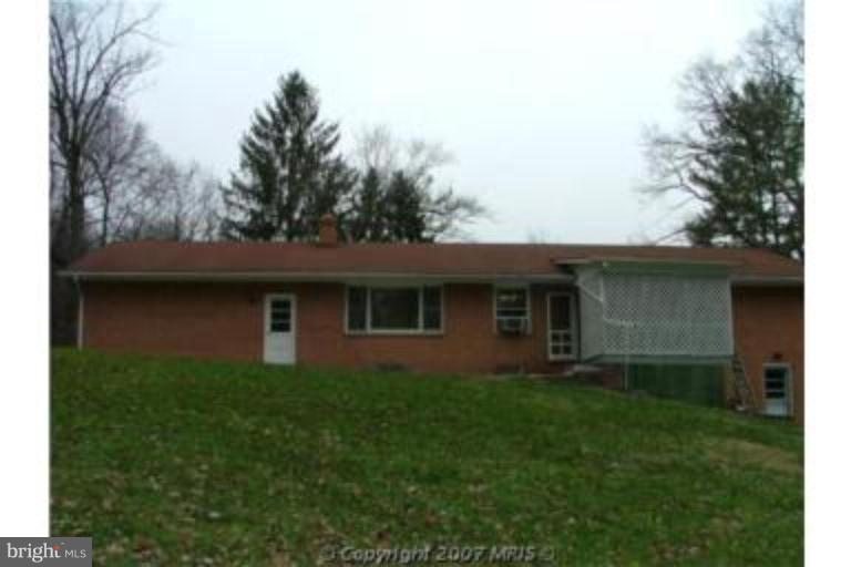 8369 Ball Road Frederick, MD 21704 - Photo 2 of 5 a brick house with trees in front of it