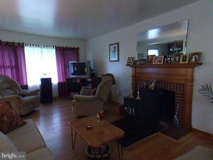 8369 Ball Road Frederick, MD 21704 - Photo 5 of 5 a living room with furniture a fireplace and a flat screen tv