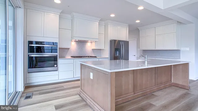 a kitchen with kitchen island granite countertop a stove and a sink
