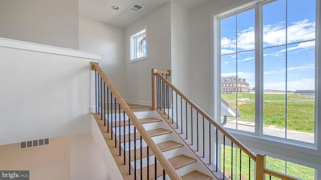 a view of staircase with railing and a large window