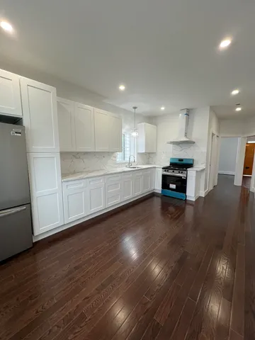 a view of kitchen with wooden floor and electronic appliances