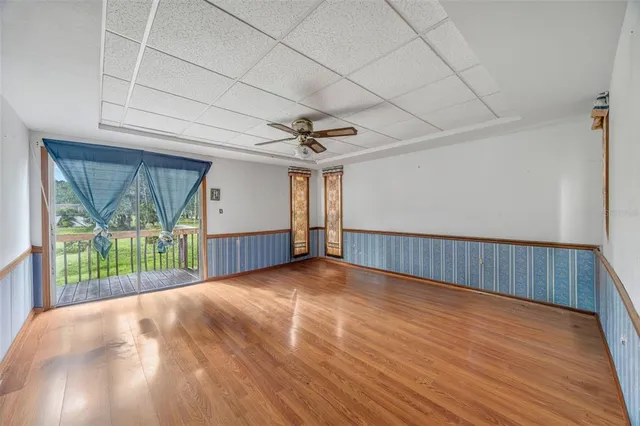 a view of a livingroom with wooden floor and a ceiling fan