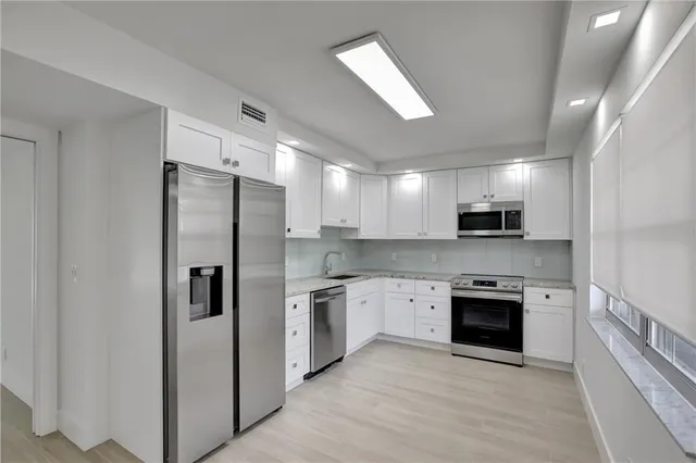 a kitchen with stainless steel appliances a refrigerator sink and stove