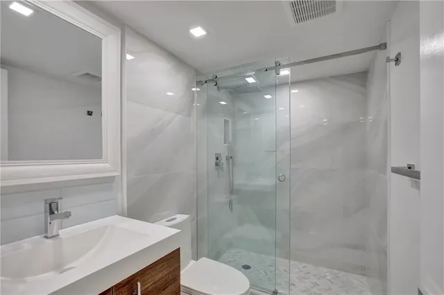 a bathroom with a sink shower and a mirror