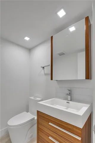 a bathroom with a sink a toilet and a mirror