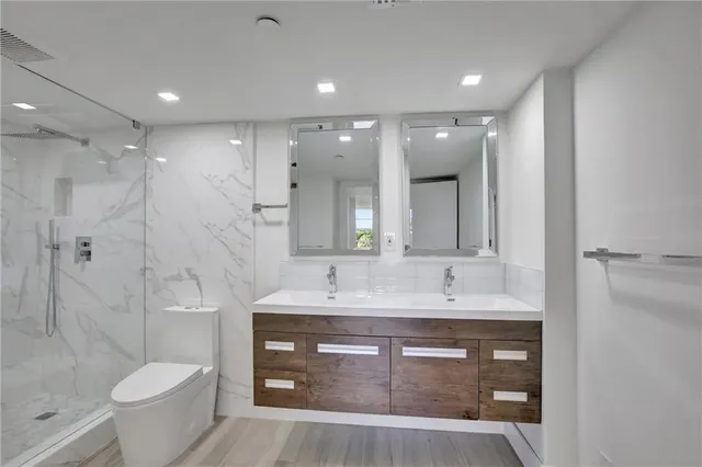 a bathroom with a sink a toilet and shower