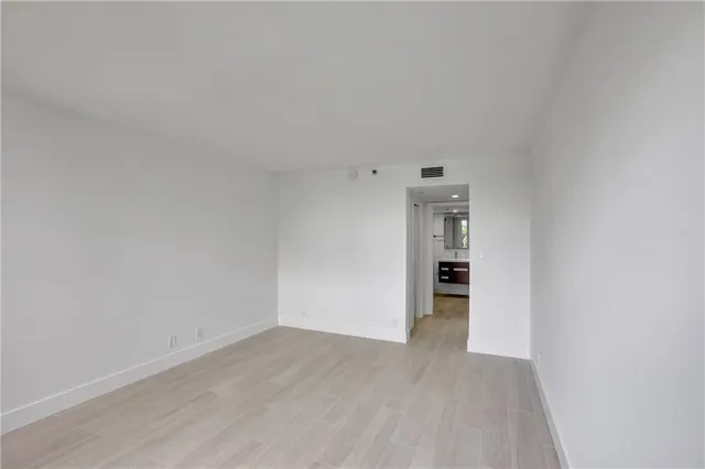 a view of empty room with wooden floor and space