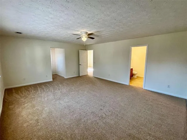 an empty room with windows and ceiling fan view