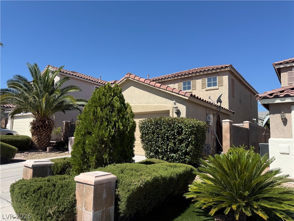1141 Cathedral Ridge Street Henderson, NV 89052 - Photo 2 of 77 This residence features a tiled roof and inviting landscaping.